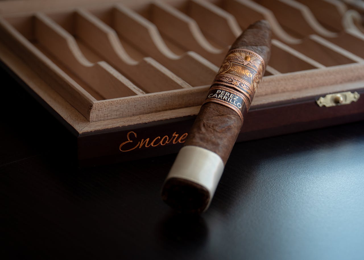 about-07 A beautifully crafted cigar resting on a wooden humidor box, showcasing luxury and craftsmanship.